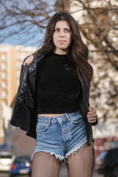 Close view of a beautiful young woman with short blue jeans on the urban city.