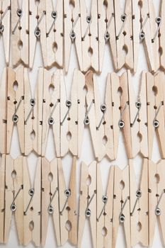 Aligned clothing pegs isolated on a white background.