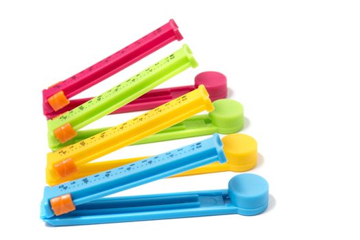 Close up view of several colorful bag clips isolated on a white background.