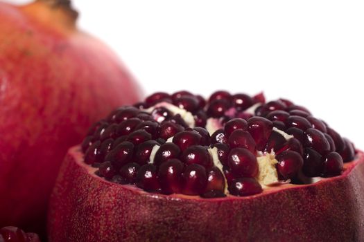 Close up view of tasty pommegranate fruit isolated on a white background.