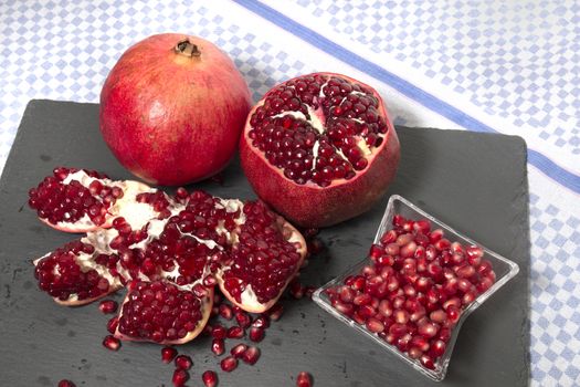 Close up view of tasty pommegranate fruit on top of a slate stone.