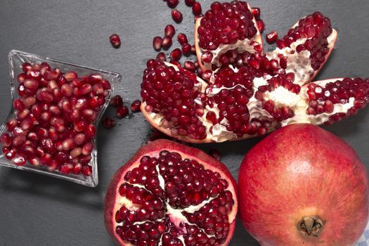 Close up view of tasty pommegranate fruit on top of a slate stone.