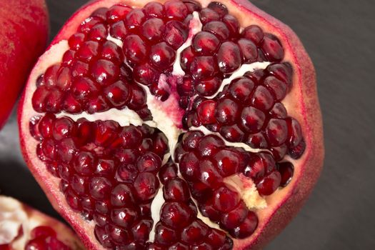 Close up view of tasty pommegranate fruit on top of a slate stone.