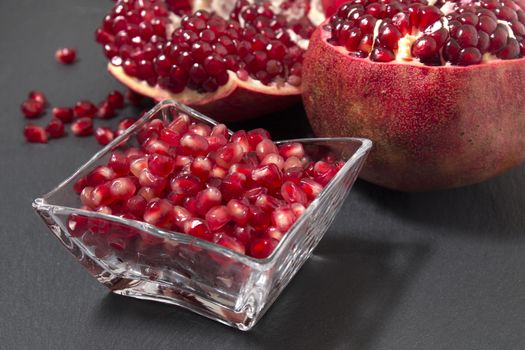 Close up view of tasty pommegranate fruit on top of a slate stone.