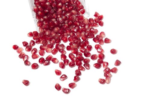 Close up view of tasty pommegranate fruit seeds isolated on a white background.