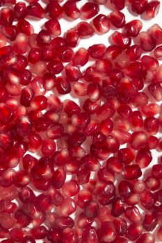 Close up view of tasty pommegranate fruit seeds isolated on a white background.