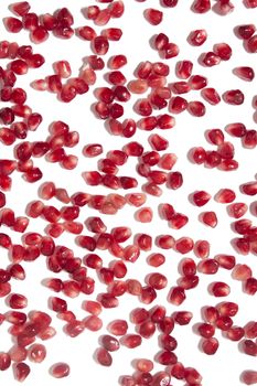 Close up view of tasty pommegranate fruit seeds isolated on a white background.