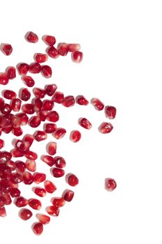 Close up view of tasty pommegranate fruit seeds isolated on a white background.