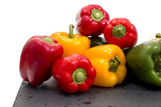 colorful bell peppers on a black stone of schist.