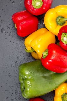 colorful bell peppers on a black stone of schist.