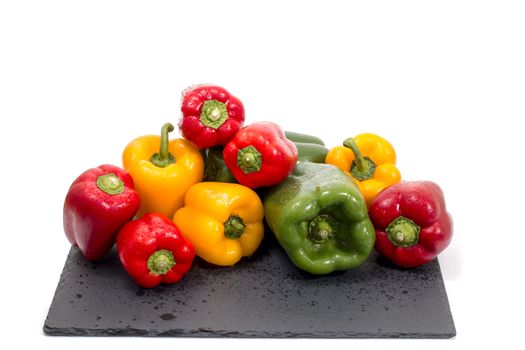 colorful bell peppers on a black stone of schist.