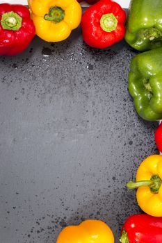 colorful bell peppers on a black stone of schist.