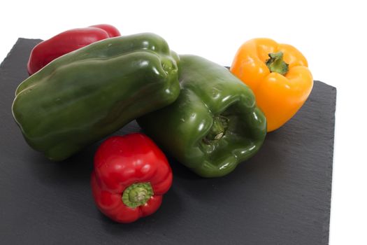 colorful bell peppers on a black stone of schist.