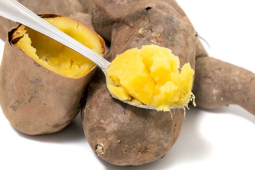 Cooked oven sweet potatoes isolated on a white background.