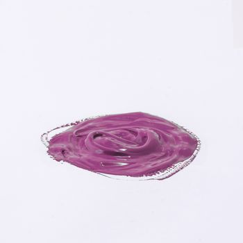 a drop of acrylic pink color on a white surface