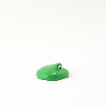 a drop of acrylic green color on a white surface