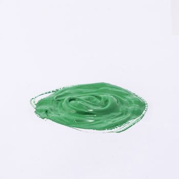 a drop of acrylic green color on a white surface