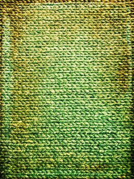 Bright green grungy knitted background. Handcrafted vintage canvas.