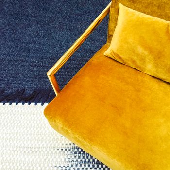 Dark yellow velvet armchair. Modern furniture with retro feel.