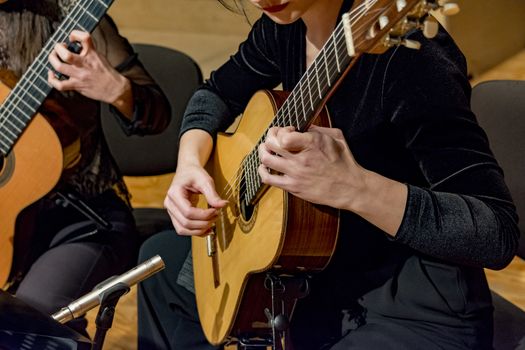 two young women playing guitar in a concert