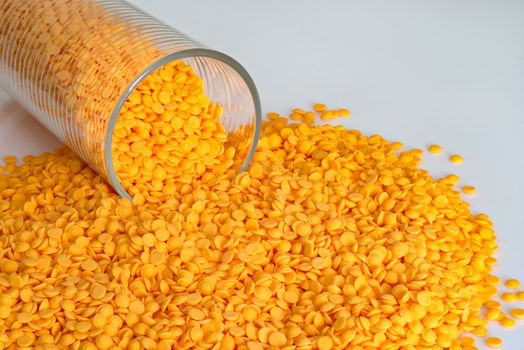 Polypropylene beads, plastic orange pellets on white color background.