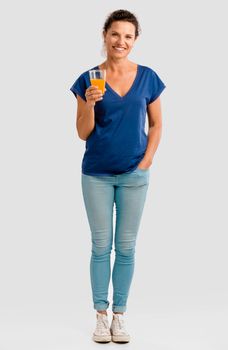 Middle aged woman holding a glass with orange juice