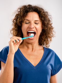 Beautiful mature woman brushing her teeths 
