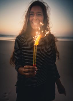 Teenage girl on the beach holding Fireworks 