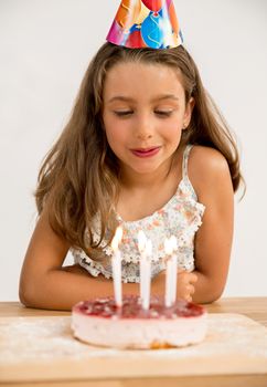 Shot of a young girl blowing out the candles on her birthday cake