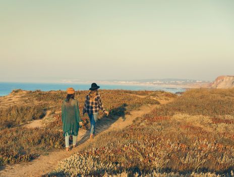 Two best friends walking on the coastline on a beautiful day