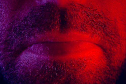 Macro close up on man mouth with serious facial expression. Portrait of expressionless young man.