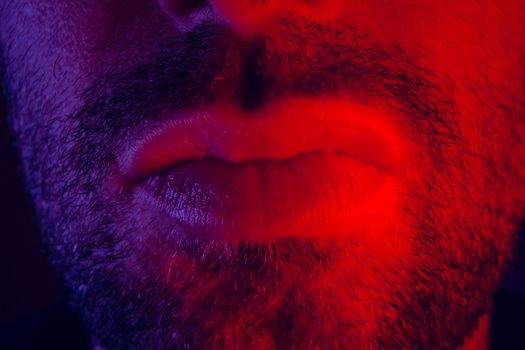 Macro close up on man mouth with serious facial expression. Portrait of expressionless young man.