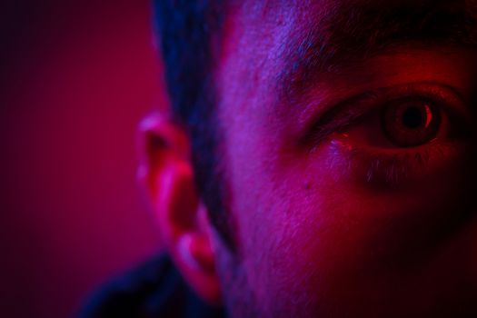 Close up on man face with mysterious facial expression. Portrait of suspicious young man.