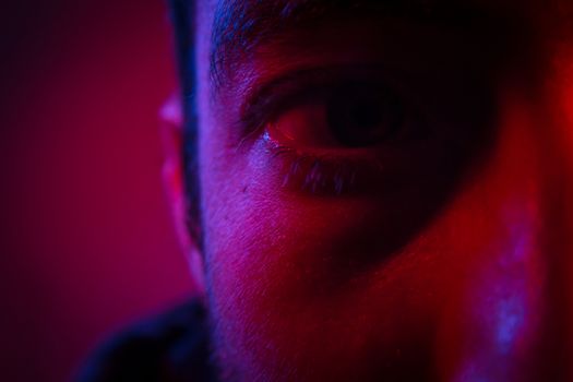 Close up on man face with mysterious facial expression. Portrait of suspicious young man.