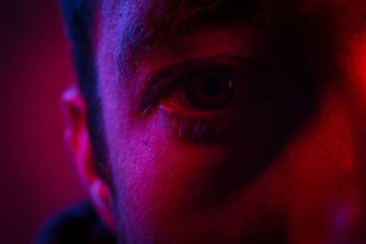 Close up on man face with mysterious facial expression. Portrait of suspicious young man.