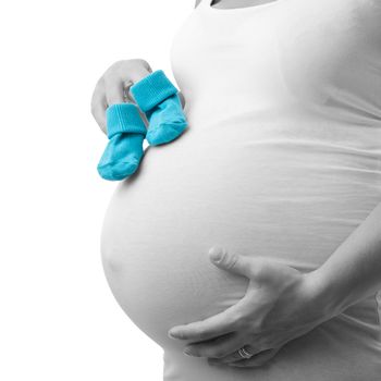 A pregnant woman is waiting for a boy. Blue socks otherwise in a black and white picture.