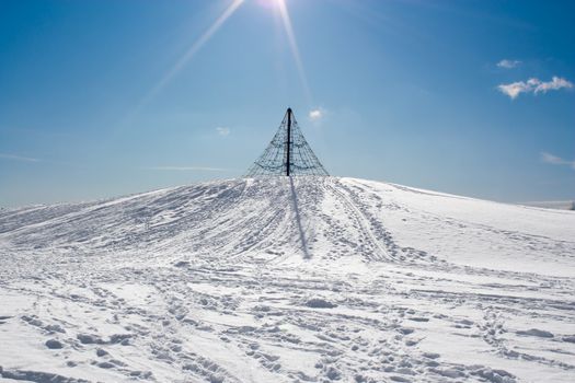 Winter image from Kotka, Finland, with a climbing frame on a snowy hill.