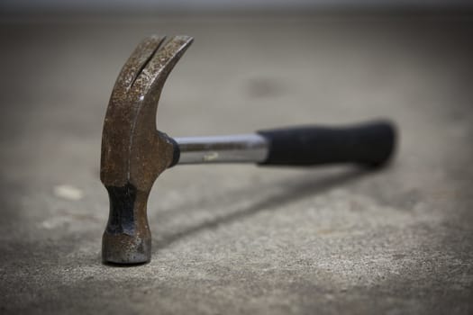 Old rusty hammer lying on the floor. A great tool even though it is old-fashioned.