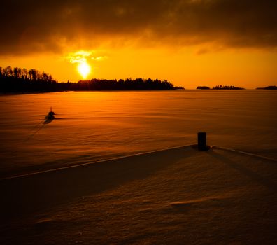 Very orange sunset in Luvia, Finland. The sea is frozen.