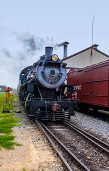 Steam Engine Locomotive with Passenger cars Arriving into Station