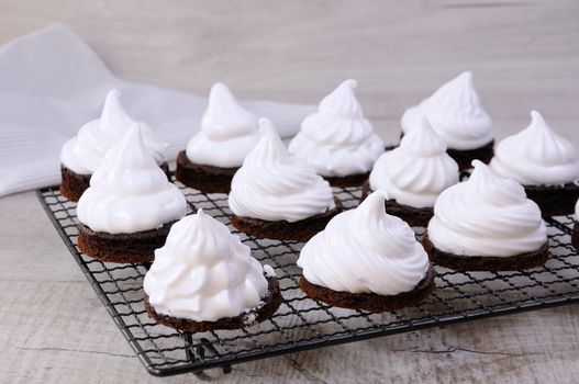 Delicate chocolate chip cookies with airy Italian meringue under   on the rack. 