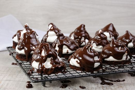 Delicate chocolate chip cookies with airy Italian meringue under chocolate glaze on the rack