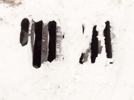 white snow on metal grate outside pavement road ; essex; england; uk