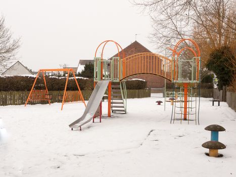 school children's playground park climbing frame outside snow winter; essex; england; uk