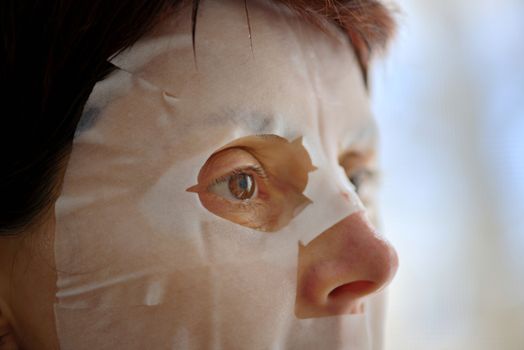 Woman with facial treatment mask sheet