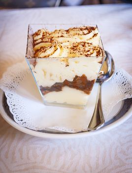 close-up view of a portion of Italian tiramisu made with mascarpone cheese, coffee and savoiardi biscuits