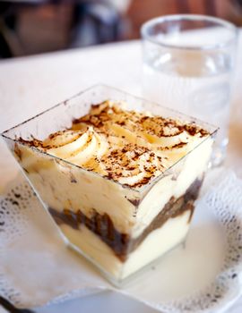 close-up view of a portion of Italian tiramisu made with mascarpone cheese, coffee and savoiardi biscuits