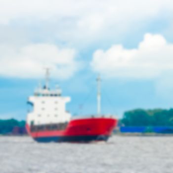 Red cargo ship - soft lens bokeh image. Defocused background