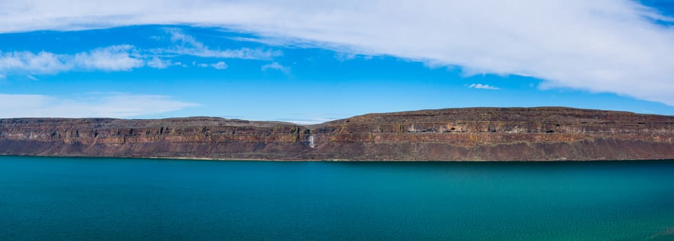 Columbia River Canyon Panorama with blue cloudy sky and deep green blue river below