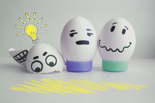 Concept of idea. Light. Cheerful eggs with two face on white background on stand concept warned. Photo for your design